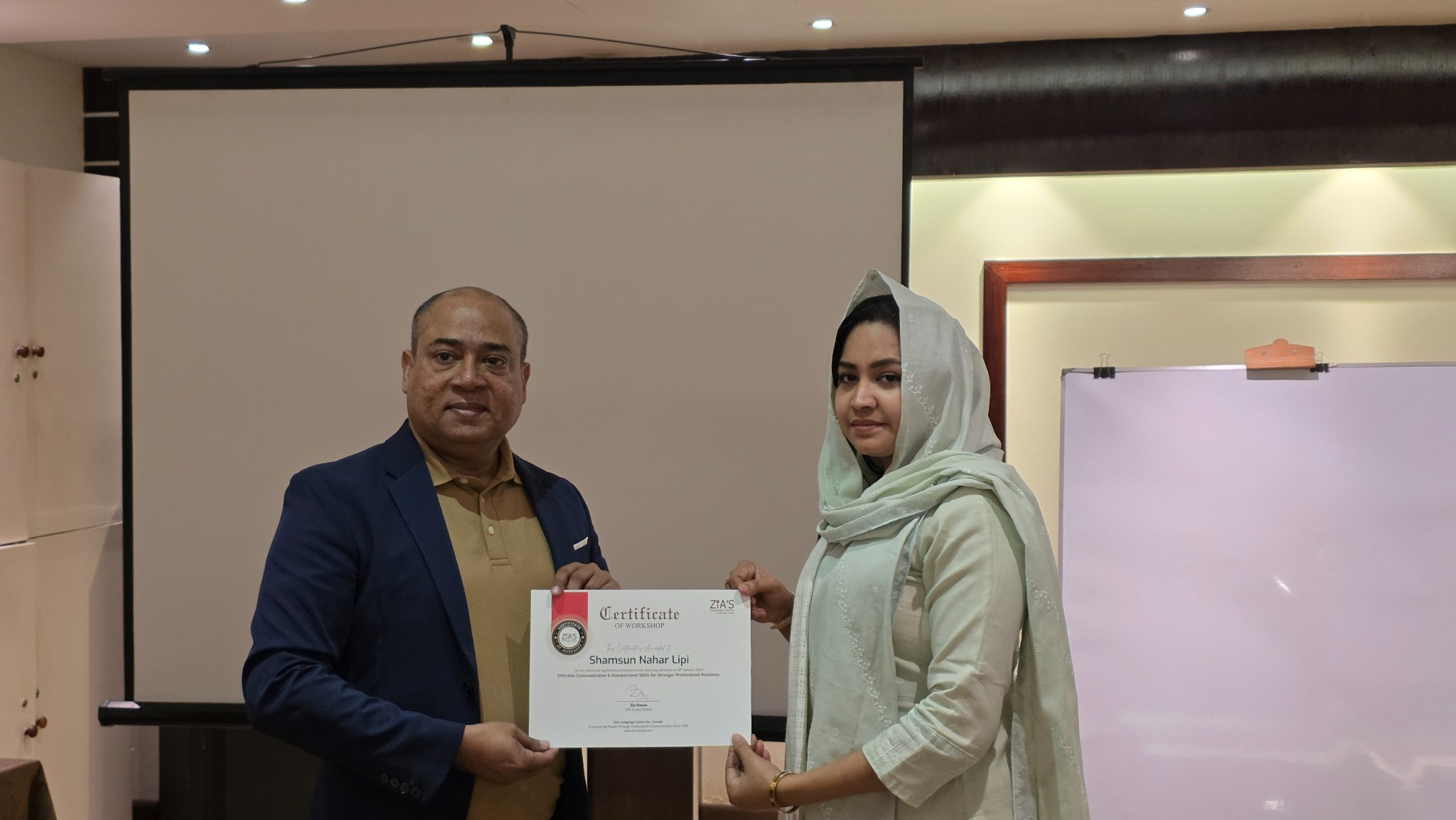 Zia Hasan presenting a workshop certificate to a participant