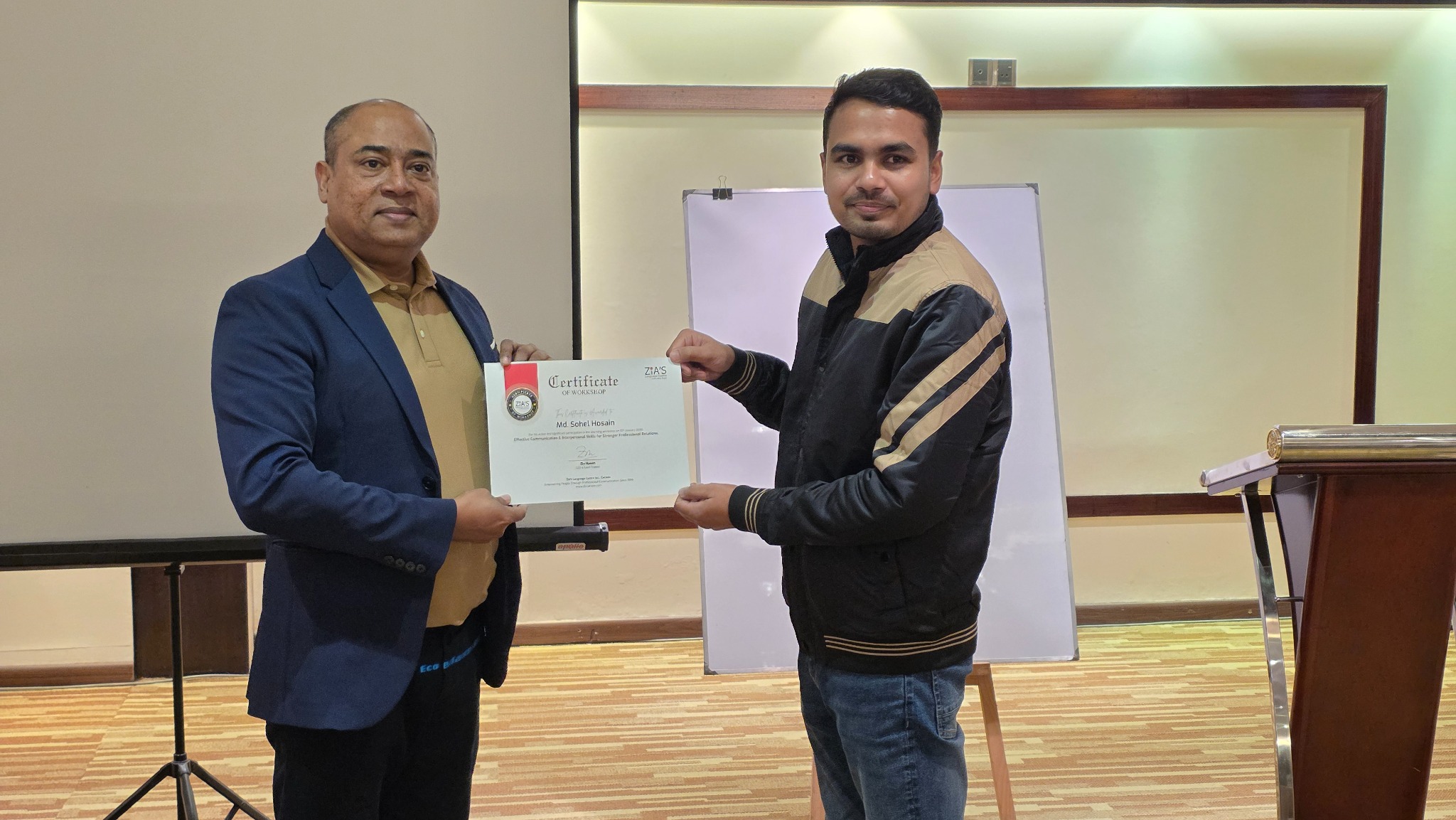 Zia Hasan presenting a workshop certificate to a participant